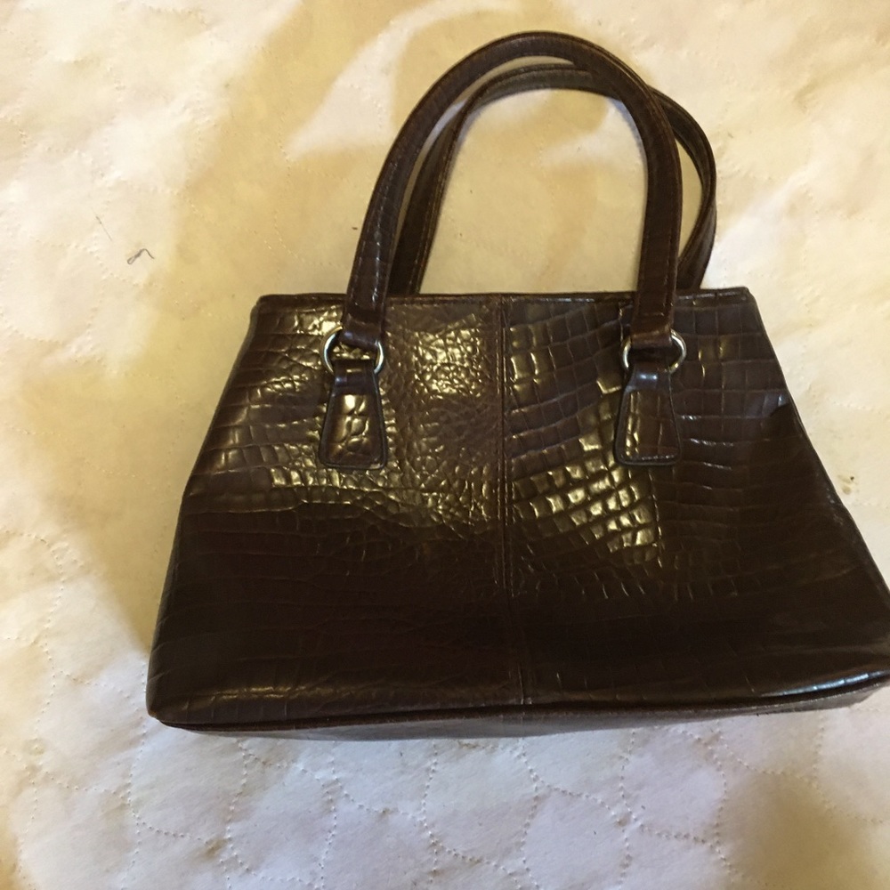 Woman’s faux leather clutch in brown.